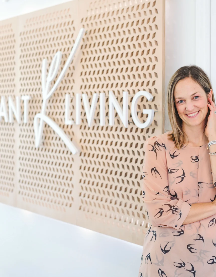 Dr. Robin Walsh, ND, smiling beside the Vibrant Living sign in the clinic